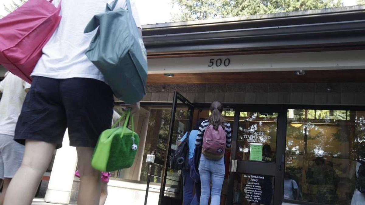 FILE PHOTO: Patrons file in as the doors open to the Lacey Timberland Regional Library.