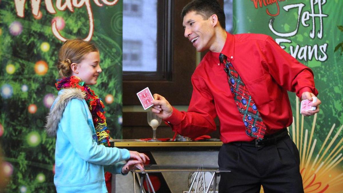 Amelia Etue, 9, of Chehalis, assists magician Jeff Evans during a performance at the Chehalis Timberland Library in 2013. Evans has two free library shows scheduled for Thursday.
