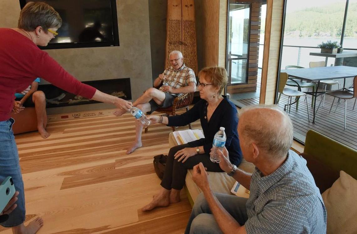 During a small Memorial Day meeting at her home Monday afternoon, Tracy Larson hands out bottled water along with her fellow Summit Lake neighbors Debra Martinelli and Jack Benjamin share their thoughts about the lake closure due to a severe toxic algae outbreak, and which also necessitates the need for the bottled water. (Tracy’s husband Vaughn Hodgins is also seen in the background)