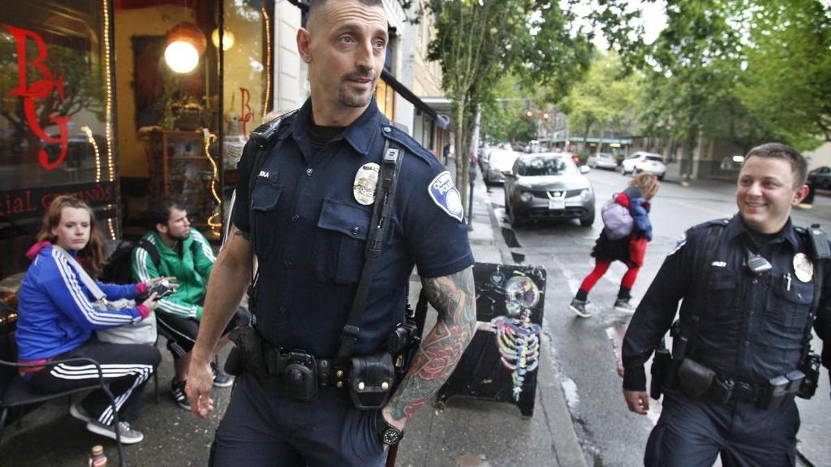 Olympia police officers Javier Sola Del Vigo (left) and Paul Frailey keep an eye on activities along Washington Street during their nightly walking patrol of downtown Olympia.