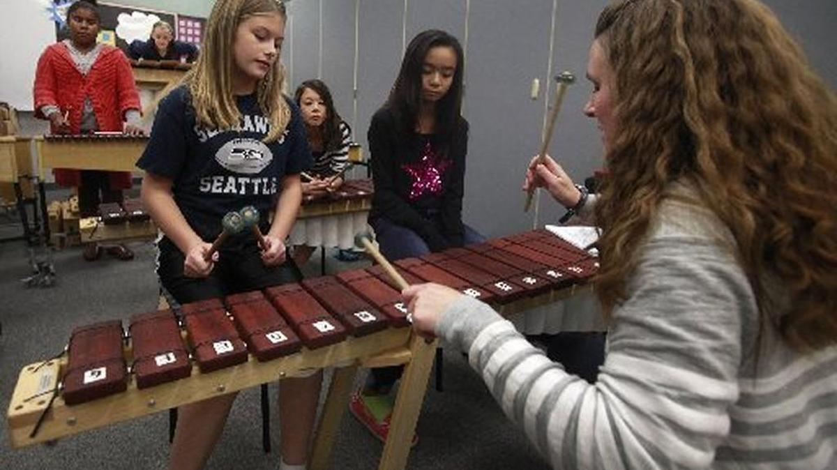 Working with her students Keeley Livingstone (left) and Lilly Nguyen Tumwater Hill Elementary School music teacher Heather Stoker leads a lunchtime 6th grade marimba group in October 2014. The Tumwater School Board plans to put a levy measure on the Feb. 9 ballot that will raise money to pay for programs such as music and smaller class sizes.