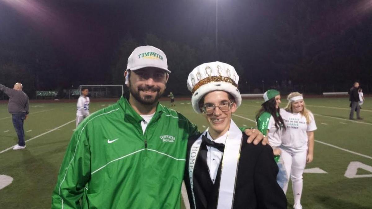 Life Skills teacher Jordan Stray, left, stands with Tumwater High School senior Noah Otto, right, who was crowned homecoming king during Friday night’s game by fellow student and brief homecoming king-elect Kyle Summers. “They put the sash over me, and I turned to one of my friends and I was like ‘I really want this to go to Noah,’ ” Summers said.