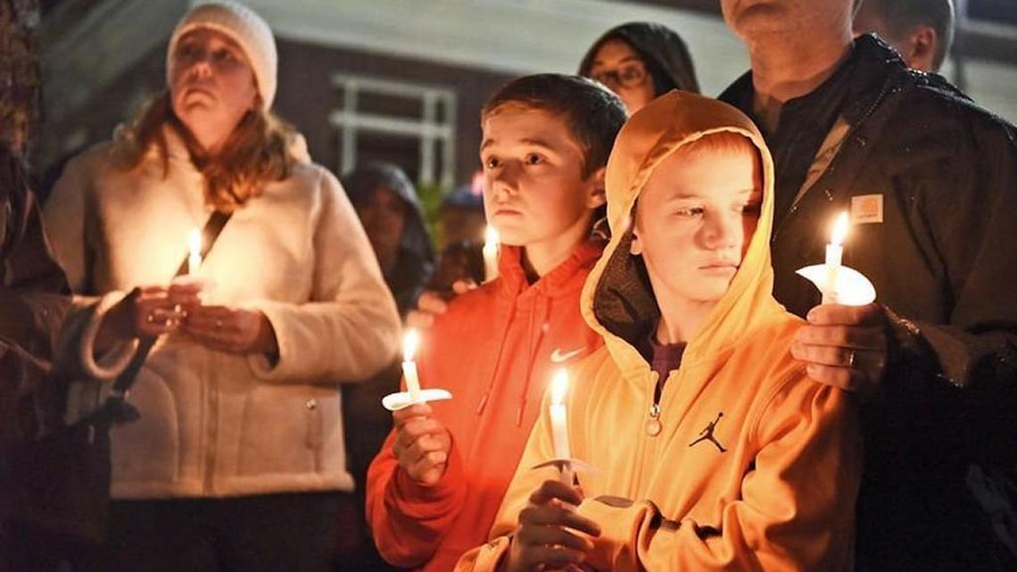 The aunt, uncle and cousins of the three children killed in Friday’s early morning house fire in Centralia hold candles Saturday night during a vigil at George Washington Park. From left are Sara Adams, in white, Corey Adams, 14, in orange, Justin Adams, 12, in yellow, and behind him Daryl Adams. The family is from Olympia.