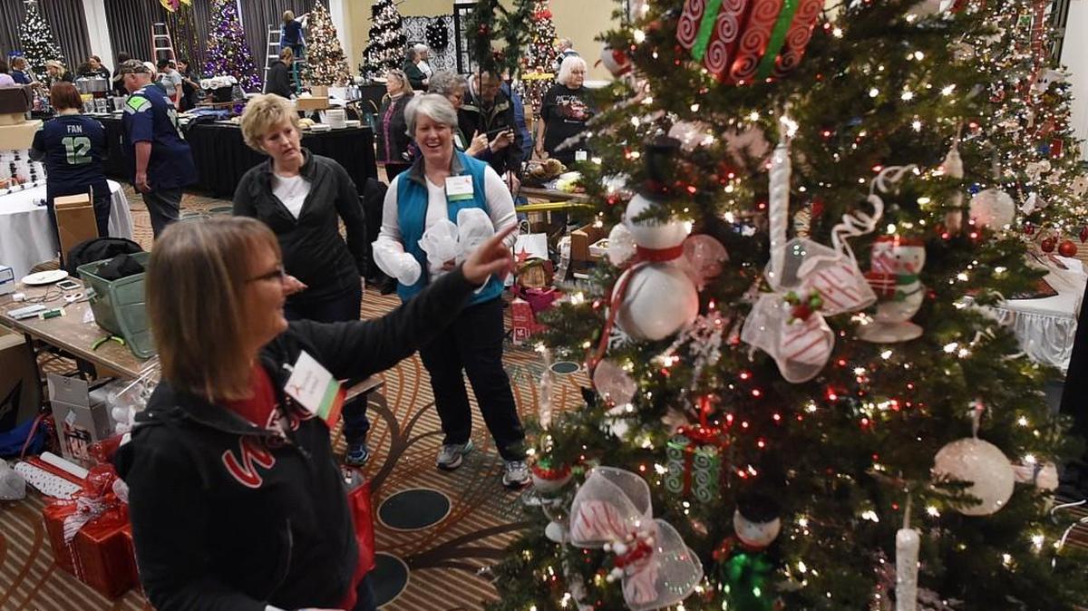 The design team of Brenda Arend, Stephanie Pedigo and Ellen Joss (left-right) take a step back to review their holiday creation during the set-up Sunday for the 2015 Providence St. Peter Foundation Christmas Forest fundraiser.