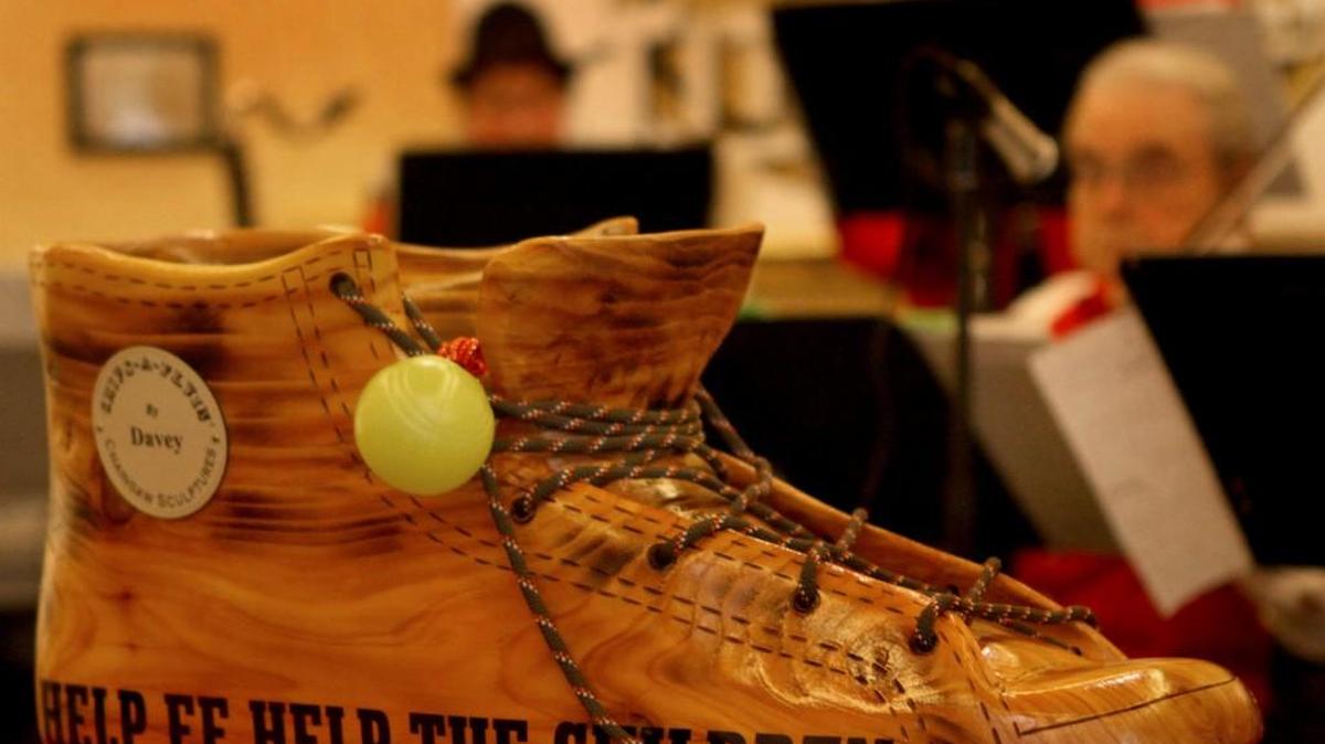A 15-pound cedar tennis shoe created by chainsaw artist Davey Gagne rests in the lobby of The Washington Center for the Performing Arts during the 2013 “A Really Big Shoe” concert.