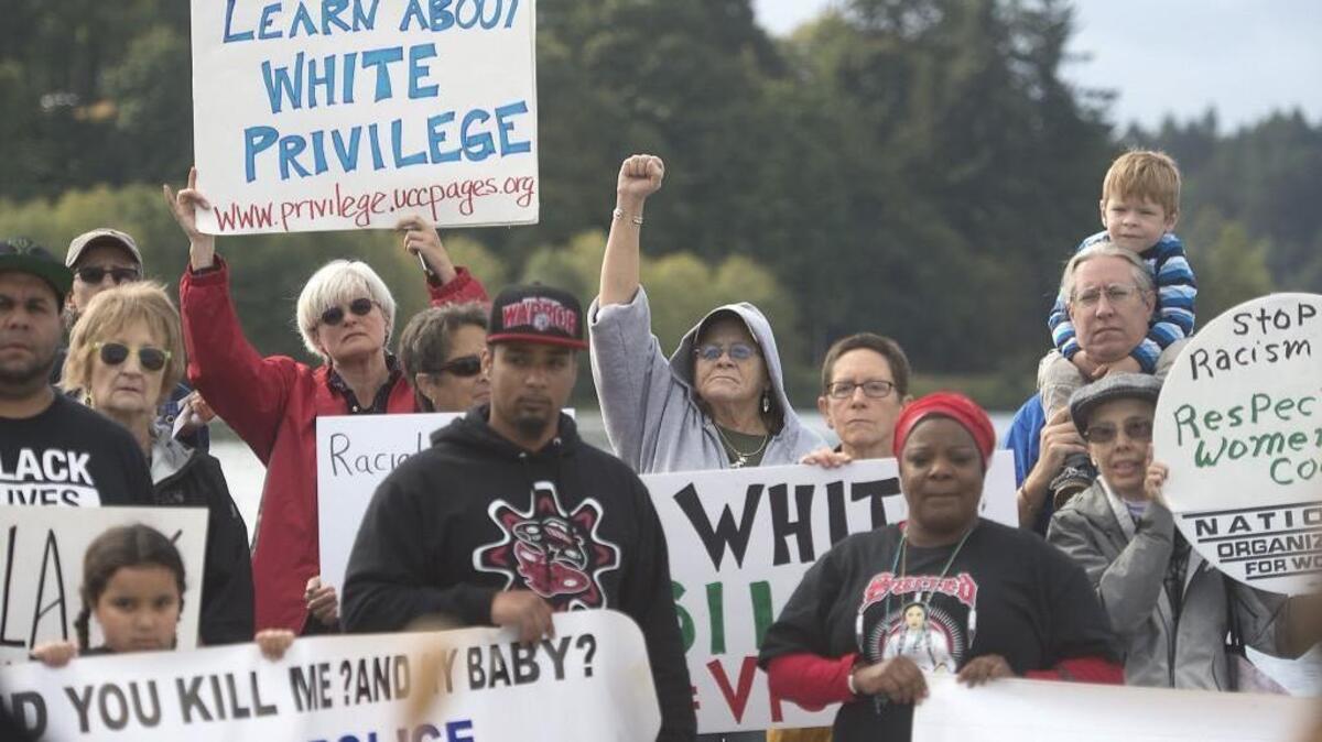 Sandy Sandven of Tumwater raises her fist during a song to open the March for Racial Justice at Heritage Park in Olympia in 2017.