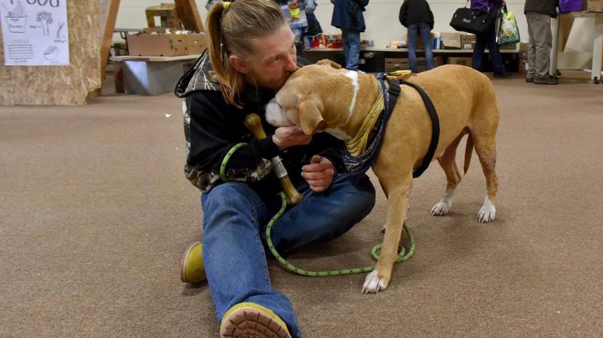 After finding a good-fitting donated dog harness, David Lee gives his dog, Keena, a kiss during their visit to the downtown Olympia warming center last January.
