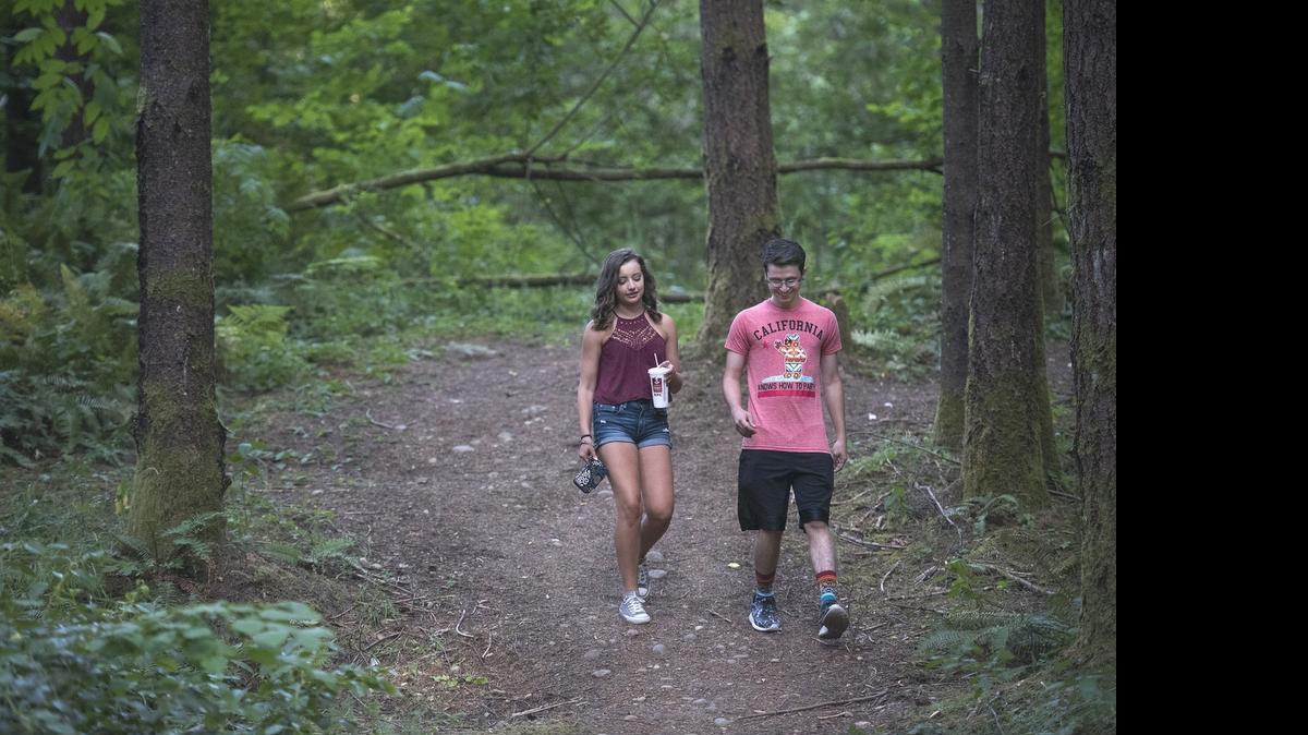 
Timberline High students Morgan Mayo and Chris Hoehne take an evening stroll Thursday along the unofficial walking trails through the 74-acre forest known as LBA Woods east of LBA Park in Olympia. 
