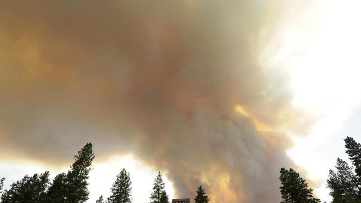 
Smoke from an approaching wildfire looms over a home near Twisp, Wash., Wednesday, Aug. 19, 2015. Authorities on Wednesday afternoon urged people in the north-central Washington town to evacuate because of a fast-moving wildfire.
