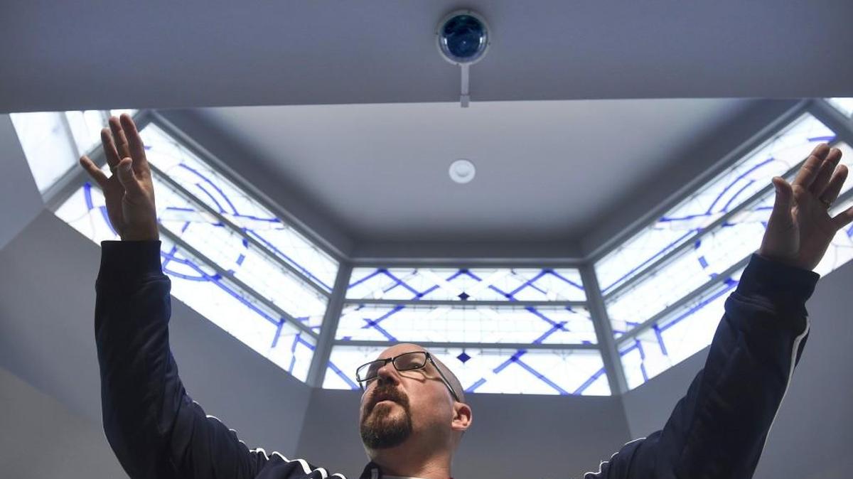 Principal Dave Myers stands Wednesday beneath a four-camera eye-in-the-sky system that is used to monitor the cafeteria at Black Hills High School in Tumwater . “My top concern is student safety,” Myers said. “I have two daughters of my own. I ask myself ‘Would I feel safe with them going to school here?’ ”
