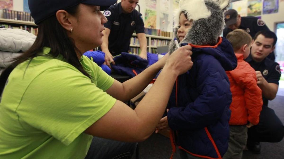 Pints Barn employee Nicole Andres helps kindergartner Kobey Prince try on his new coat as part of the Coats for Kids’ project Monday at Tumwater Hills Elementary School. A partnership between the Tumwater Firefighters, IAFF Local 2409 and Operation Warm, a national organization,provided brand-new winter coats to students in kindergarten through 4th grade at the school. Andres’ Tumwater area restaurant was a sponsor of the local coat give-away.