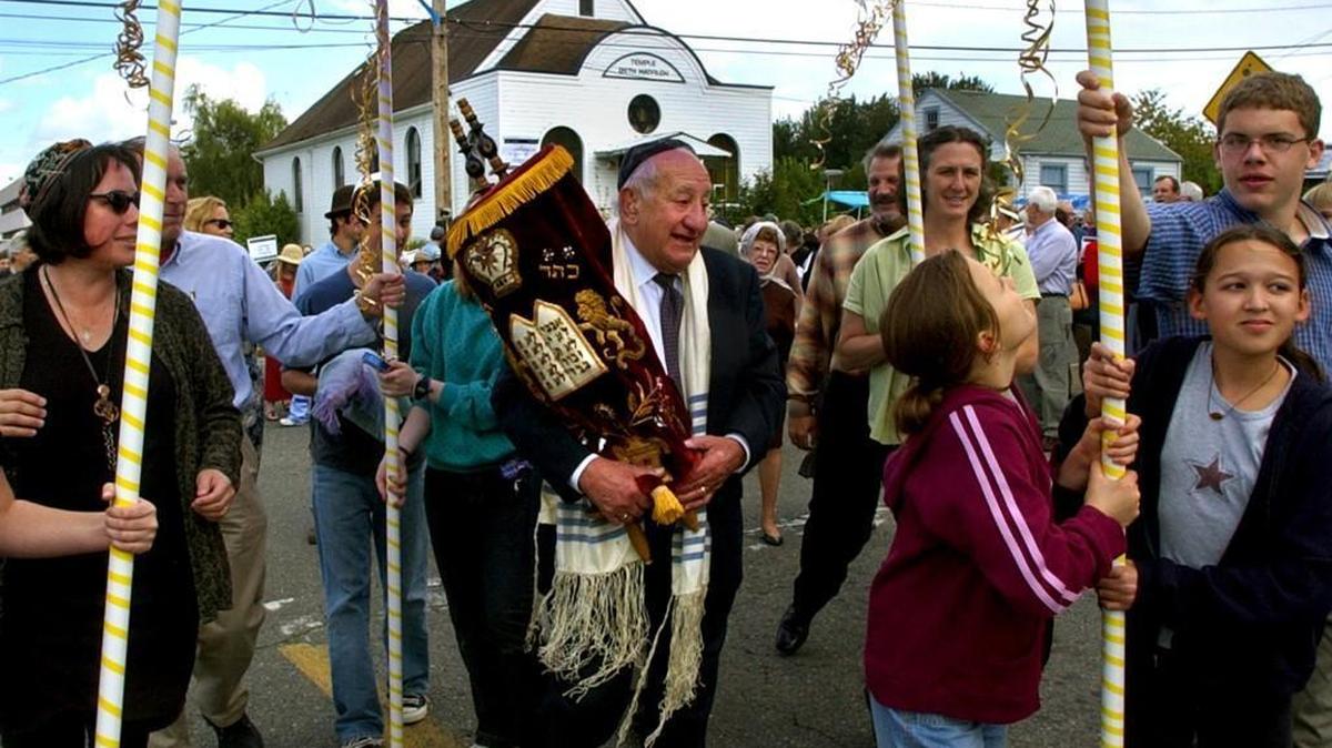 Carrying his family’s torah scroll, which has been handed down through generations, Ben Bean leads a procession of several hundred from the old Temple Beth Hatfiloh to their new home three blocks away in downtown Olympia during the congregation’s building dedication in 2004.