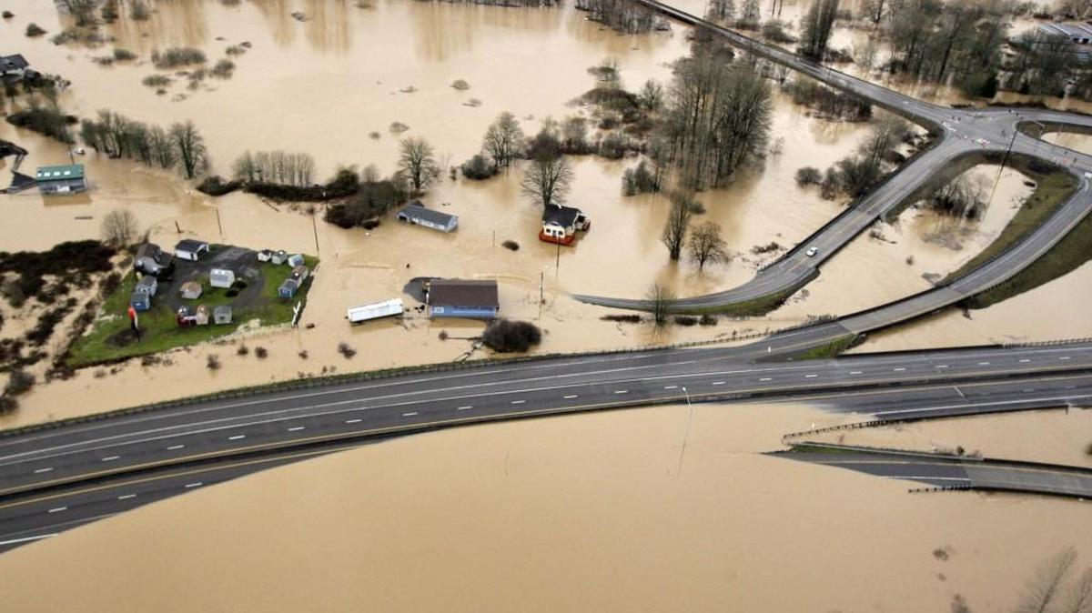 This 2009 photo shows Interstate 5, bottom, partially covered by floodwaters from the Chehalis River. In early 2009, heavy rains and melting snow caused flooding in parts of Washington, leading to a leak in the earthen abutment of the Howard Hanson Dam. Officials in King County and several cities placed giant sandbags atop downstream levees, erected flood guards around facilities such as a jail and sewage treatment plant, and temporarily relocated the county election office. “FEMA staff told us, ‘We understand why you did what you did, and it was a reasonably prudent thing to protect the public,’” said Mark Isaacson, King County’s wastewater treatment director who at the time led its flood control division. But “it didn’t fall within their definition of imminent flooding.”