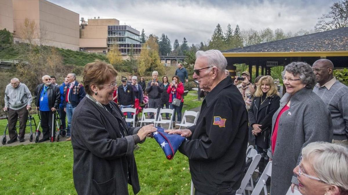 State Sen. Karen Fraser presents an American flag to Eugene "Frank" Jones in a Veterans Day ceremony at Tumwater Falls Park. Jones served in World War II, the Korean War, and the war in Vietnam. Before the flag was presented to him, it was flown over a veterans cemetery in Normandy, France, and over the state and national capitol buildings.