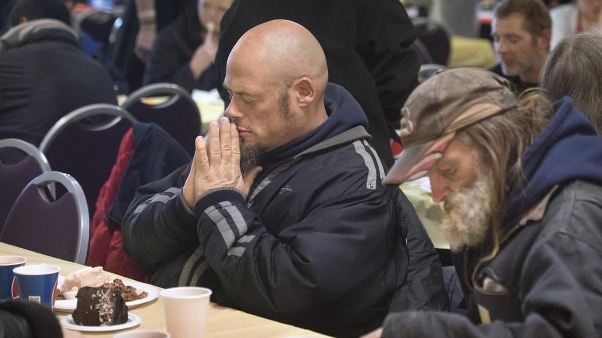 Chris Kieran of Lacey says grace before he eats at Barb's Family and Friends free holiday meal in 2015. This year’s holiday meal will be served from noon to 5 p.m. Saturday at First United Methodist Church in Olympia.