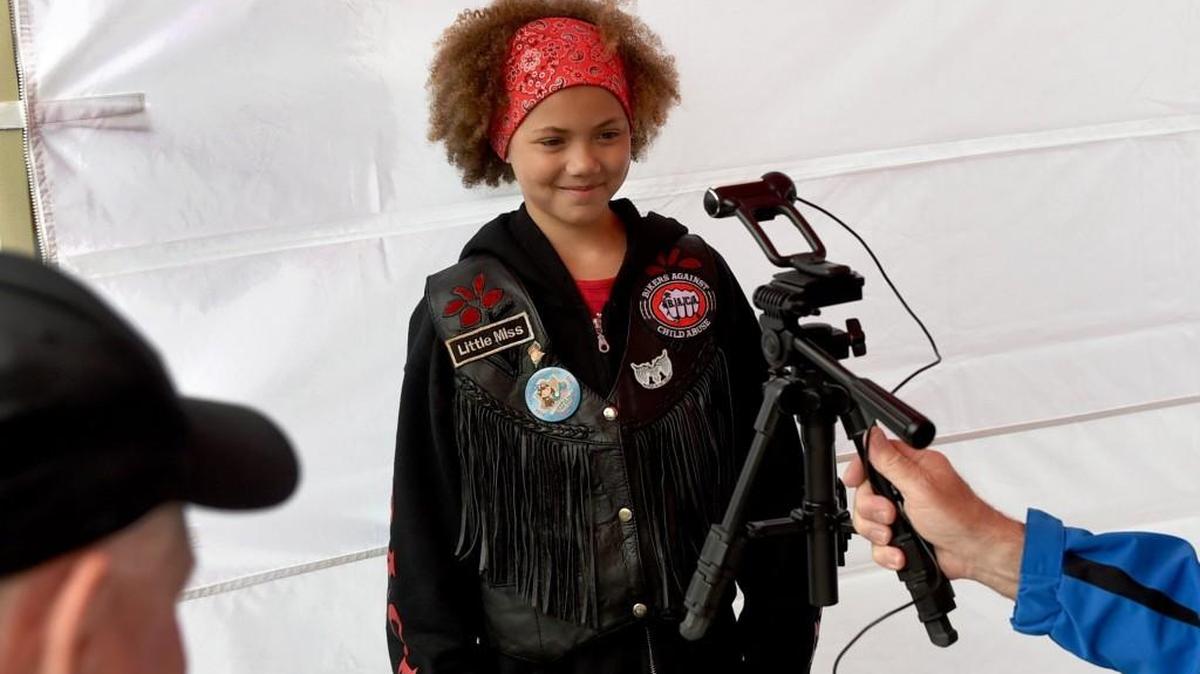 Cynthia Miller, 9, gets her photo taken and information card created by volunteers at the My ID Club booth during Missing Children’s Safety Day at the Tumwater Walmart on Sunday.