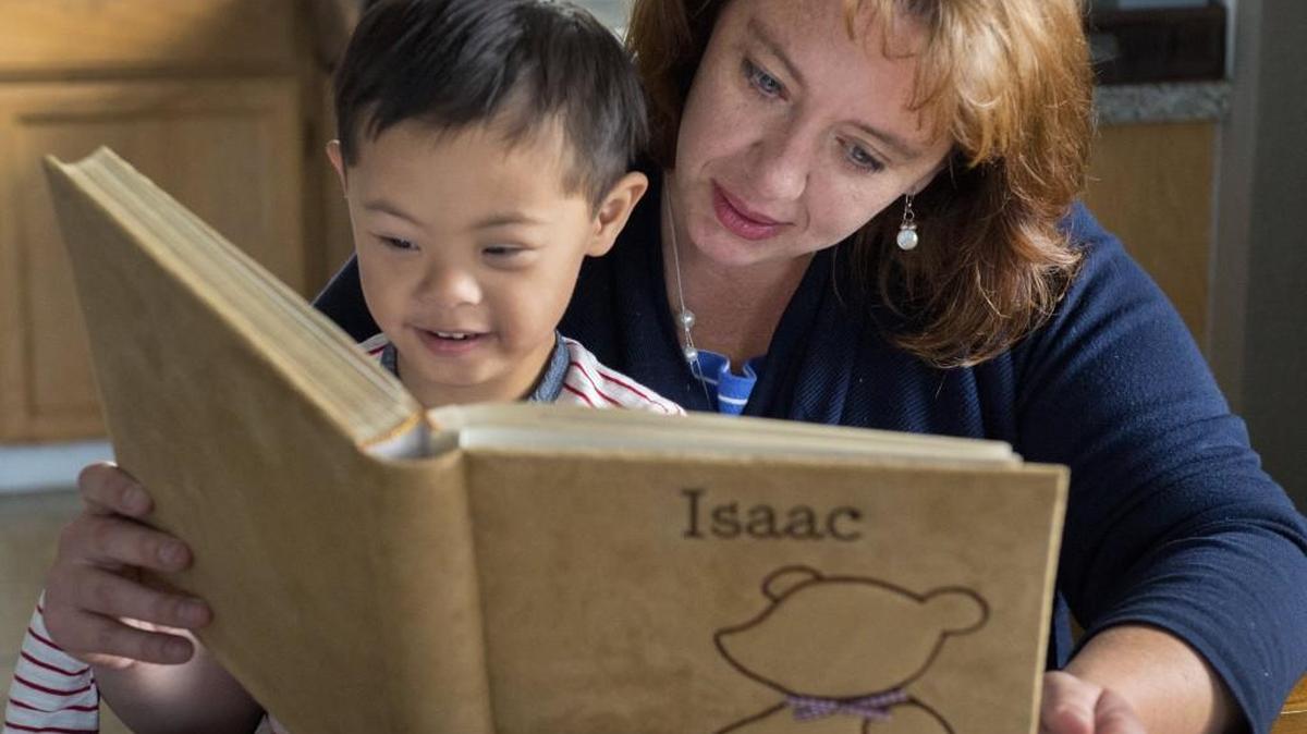 
Desiree White and her son, Isaac, 4, delight in looking at a photo album of his young life at their Tacoma home Sept. 16. When White adopted her son three years ago, adoption of children from China with Down syndrome was almost unheard of. Since then, she has become instrumental in supporting The Bamboo Project, which helps families adopt children with the condition. 
