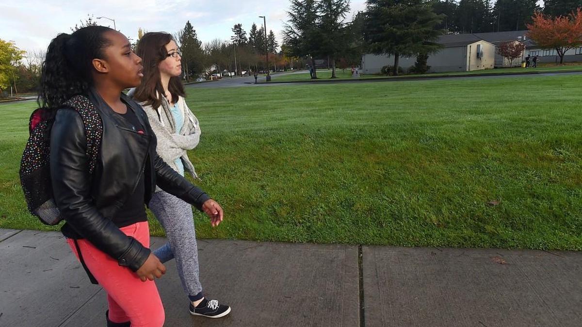 Enjoying a welcomed morning dry weather break on Oct 29th Komachin Middle School students Alliah Burke (left) and Maya McKinney near the campus on their daily walk to class as the North Thurston Public Schools works on changes to its school boundary parameters. A proposed configuration of the district’s new boundaries would have the girls bused to Chinook Middle School instead of their current 10-minute walk to Komachin Middle School.