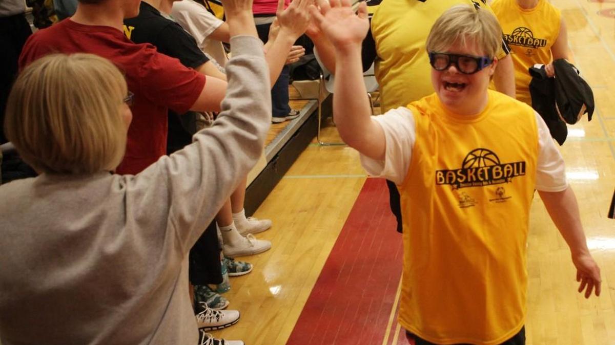 More than 80 local Special Olympics athletes are greeted by spectators as they enter Capital High School before the Pack the Gym basketball tournament.