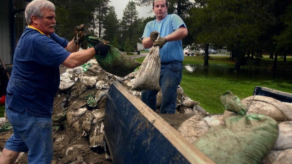 FILE PHOTO: Tom Gibb (left) and his son-in-law, Josh Spahr, load sandbags into a truck as they prepare to set up a barricade around Gibb's home on Walter Court in Tumwater in 2006.