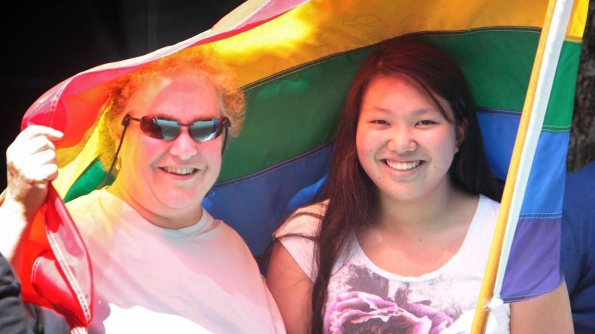 Mary Pontarolo, director of the SafePlace domestic violence shelter in Olympia, and her daughter, Maia Pontarolo-Reid, take cover from the sunshine during the Capital City Pride Day parade in downtown Olympia on Saturday, June 22, 2013. A fundraiser for Capital City Pride is planned for Thursday, March 31.