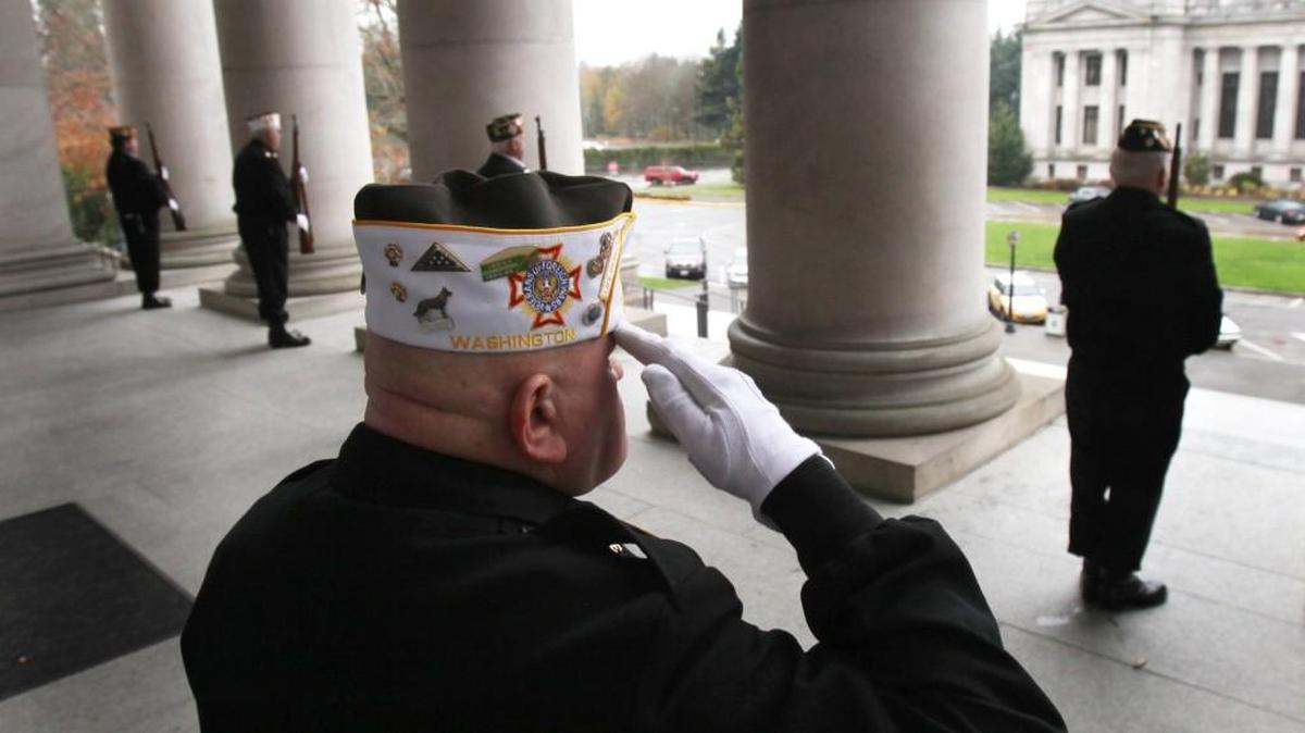 Honor guard commander Ken Wojczynski stands with the VFW Ira Carter Post 318 rifle squad during the playing of taps at the conclusion of the 2012l Veterans Day remembrance in the Capitol Rotunda.