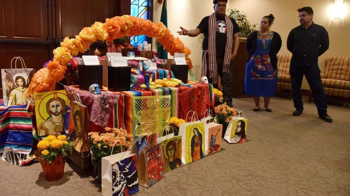 Mauricio Martinez (left), Karlah Tanori and Eric Villar explain the importance of the Dia de los Muertos altar at the start of the 2016 Interfaith All Souls Day Service at Mills & Mills Funeral Home and Memorial Park in Tumwater. This year’s service is Sunday.