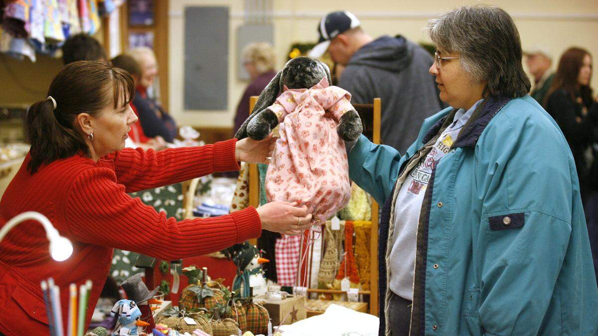 Toni Marsh (left) of Olympia looks at the handmade plush rabbit and pajama outfit that Gina Deaton of Roy put together for her newborn granddaughter during the Holiday Bazaar arts and crafts sale at the Thurston County Fairgrounds in 2011.