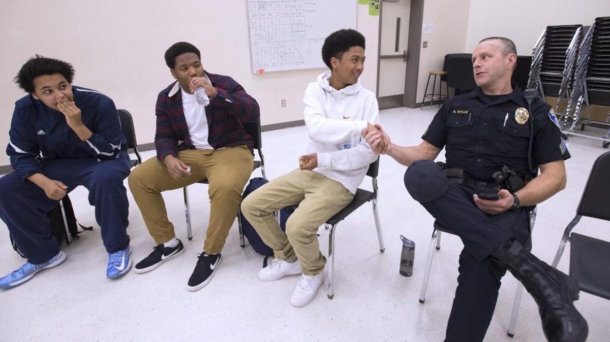 Olympia police Sgt. Bryan Wyllie introduces himself to Olympia High students (from left) Malachi Matheney, 16, Amir Matheney, 16, and Kardel Arnold, 15, during a City of Olympia public forum for the Ad Hoc Committee on Police and Community Relations on Thursday, Jan. 21, 2016.