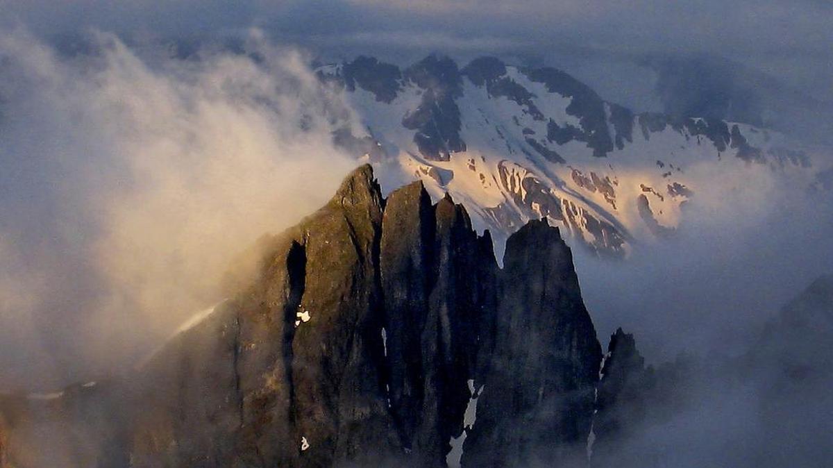 The Triplets emerge from the clouds in North Cascades National Park.