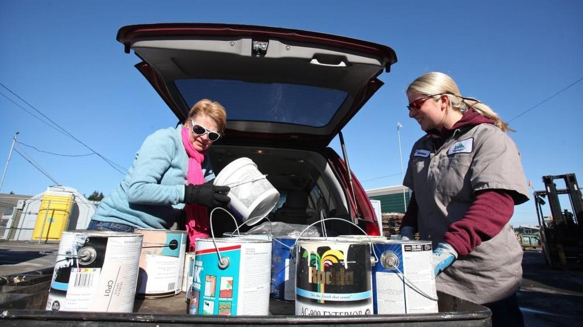 Autumn Norbeck (right) helps Vicki Tobin unload cans of house paint at the Thurston County HazoHouse in the Hawks Prairie Waste and Recovery Center.