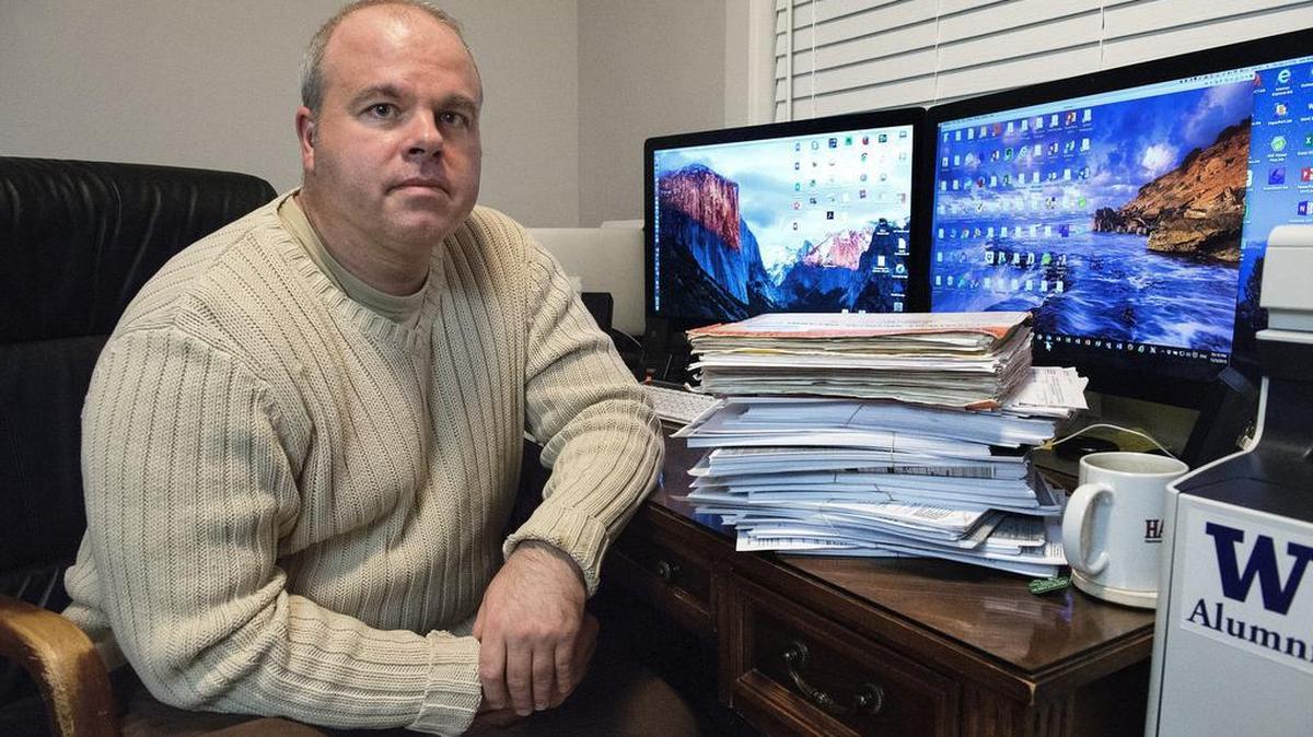 Maj. Eric Smith in the office of his University Place home with a stack of his medical records. Smith was convicted of cocaine use two years ago, based on a contaminated urine sample. He received clemency after serving seven months in jail at JBLM. Since then, an appeals court has overturned his conviction.