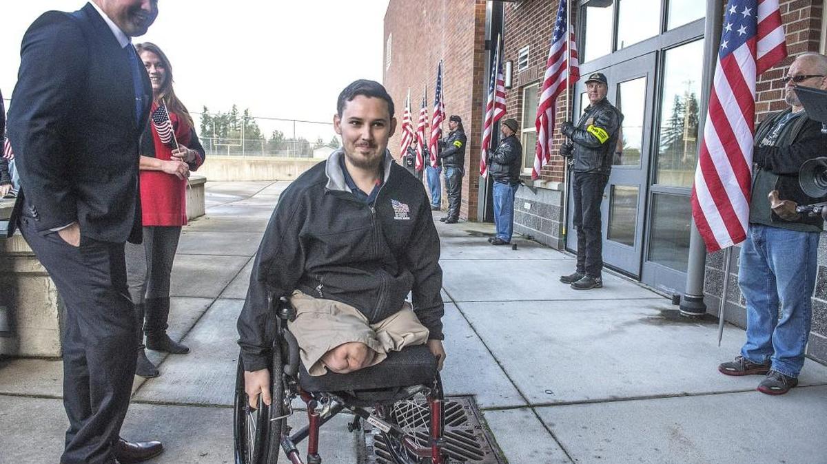 Double amputee Afghanistan veteran Sam Shockley wheels himself past the Patriot Guard to a Homes for our Troops groundbreaking and welcoming event Saturday in Eatonville to celebrate a new custom home that will be built for him and his wife, Emely.