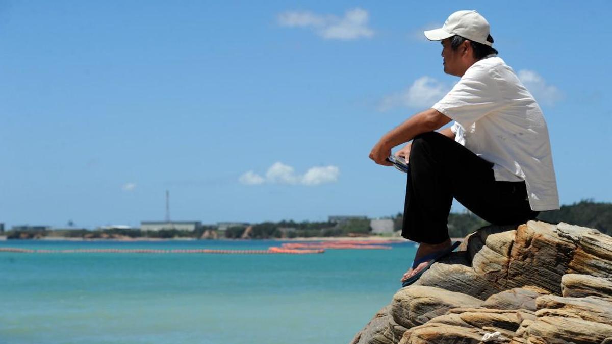 Takuma Higashionna looks across the blue waters of Oura Bay towards Camp Schwab on July 23, 2015. Higashionna, who has memories of swimming with the dugong, is against plans to fill in a large portion of the bay to build airstrips for the U.S. military. The environmentally sensitive area is home to many species of coral, fish, and the Okinawan dugong, a mammal protected by the Japanese government.
