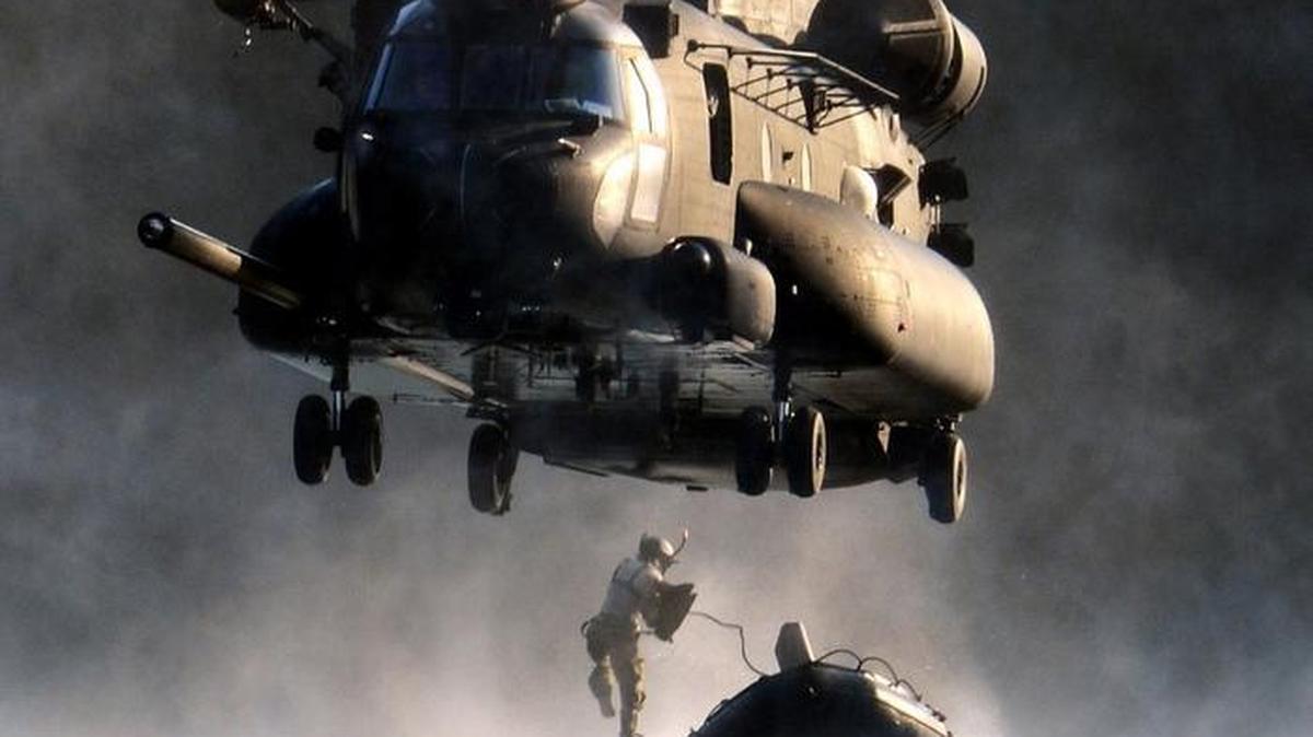 An airman jumps out of an MH-47 Chinook helicopter during an exercise with soldiers from the 160th Special Operations Aviation Regiment at American Lake on JBLM. The military is looking for new places for its helicopter units to train in Washington state.