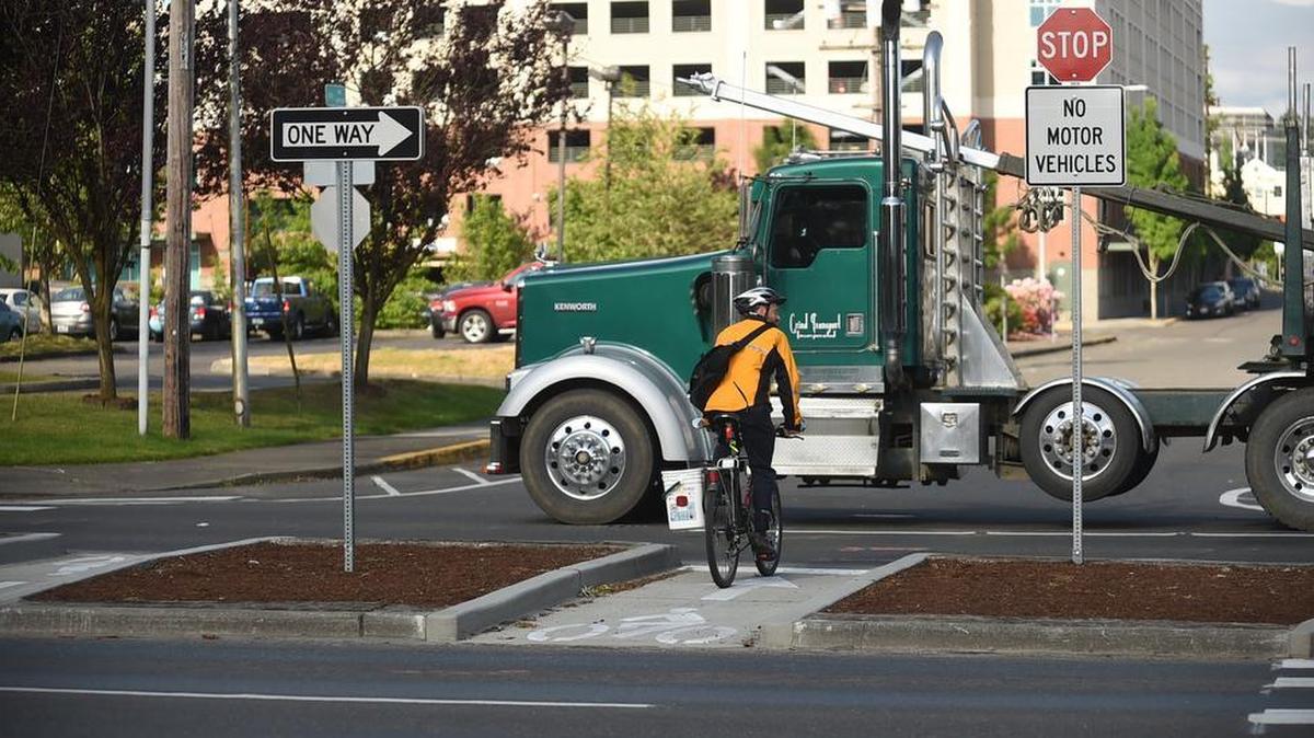 Cyclist Dave Catterson waits in the lane island of Olympia’s new bike corridor project at Plum Street and Seventh Avenue early Tuesday.