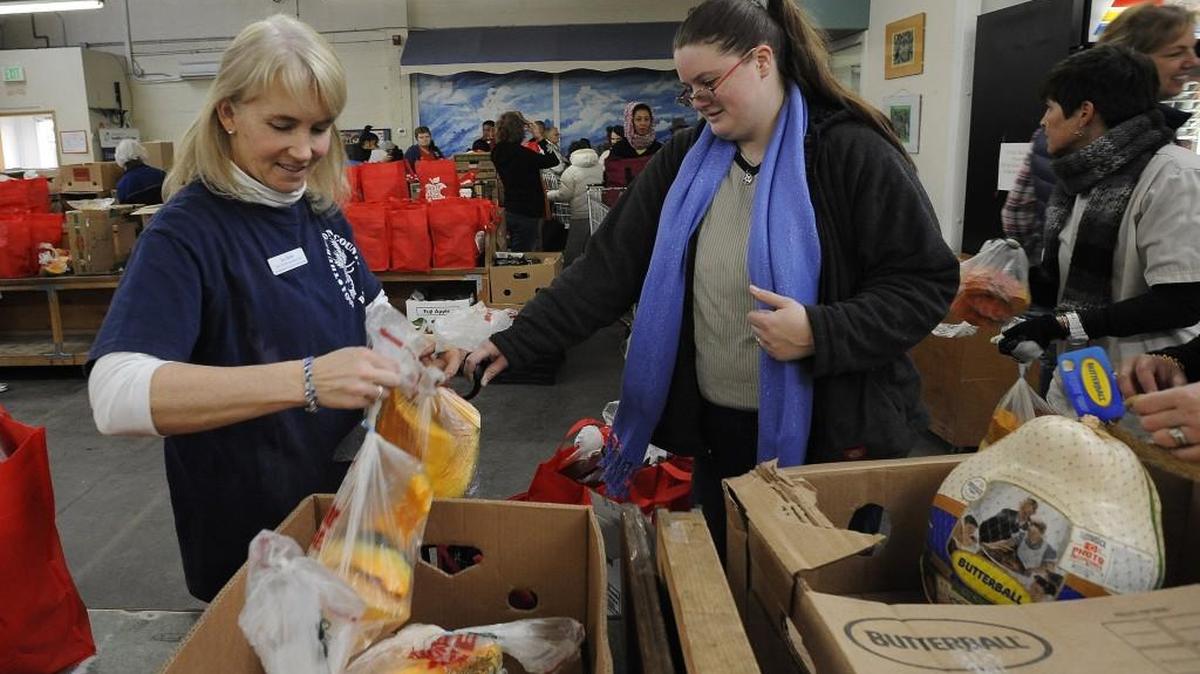 Thurston County Food Bank volunteer coordinator Jen Butti helps Diana Wilks with one of the approximately 4,000 Thanksgiving food baskets that were expected to be distributed starting Monday.