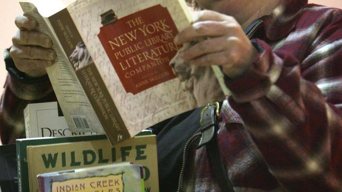 Leeann McGarity of Olympia browses some of the thousands of books on display during the annual used book sale at Lincoln Elementary School in Olympia. Videos and toys will also be on sale.