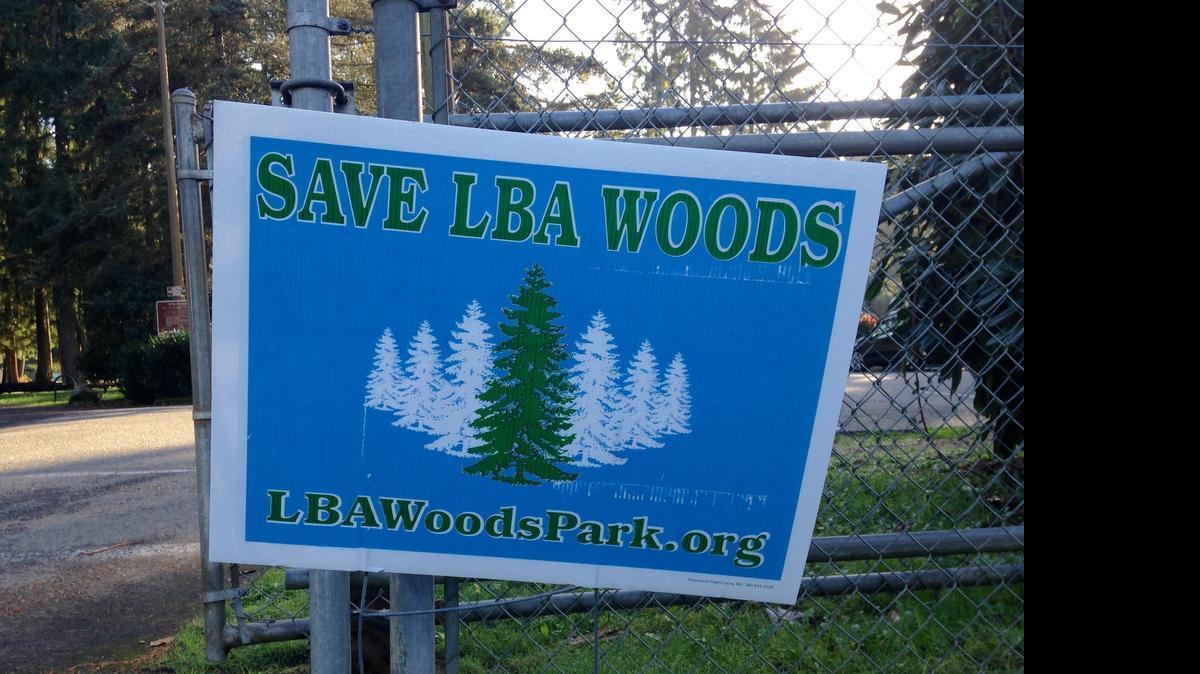 
2014 file photo: The LBA Woods Park Coalition has gathered thousands of signatures - and has installed several signs like this one - to support the purchase of properties that are currently slated for housing developments in southeast Olympia.

