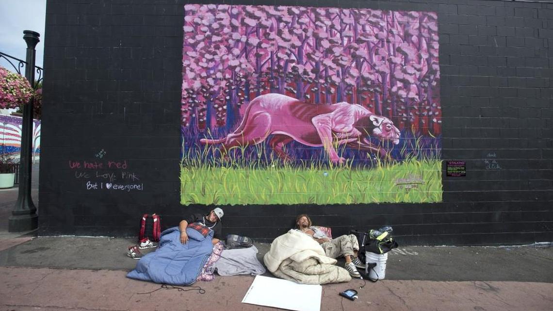 Two men sleep at the Artesian Commons in downtown Olympia last July. The city plans to hire a homeless response coordinator using a donation from Evergreen Christian Community.