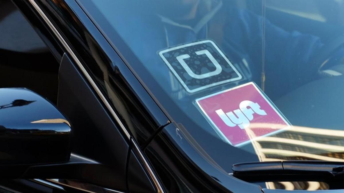 A driver displays Lyft and Uber stickers on his front windshield Jan. 12 in downtown Los Angeles.