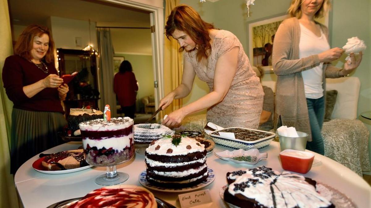Daniela Bremmer slices the delicious array of desserts brought by longtime friends Sunday afternoon as they celebrated the 30th year of the holiday "weihnachtskaffee" gathering she hosts at her Lacey home.
