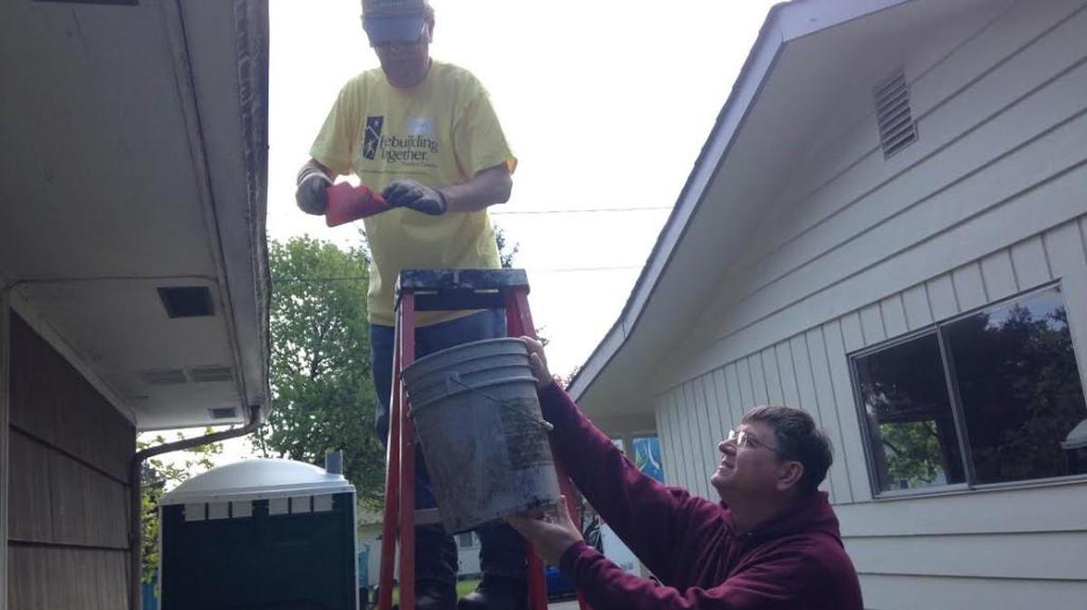 Lacey resident Gary Proctor (left) and Tumwater Mayor Pete Kmet clean the gutters of a Tumwater home during Rebuilding Day on Saturday.