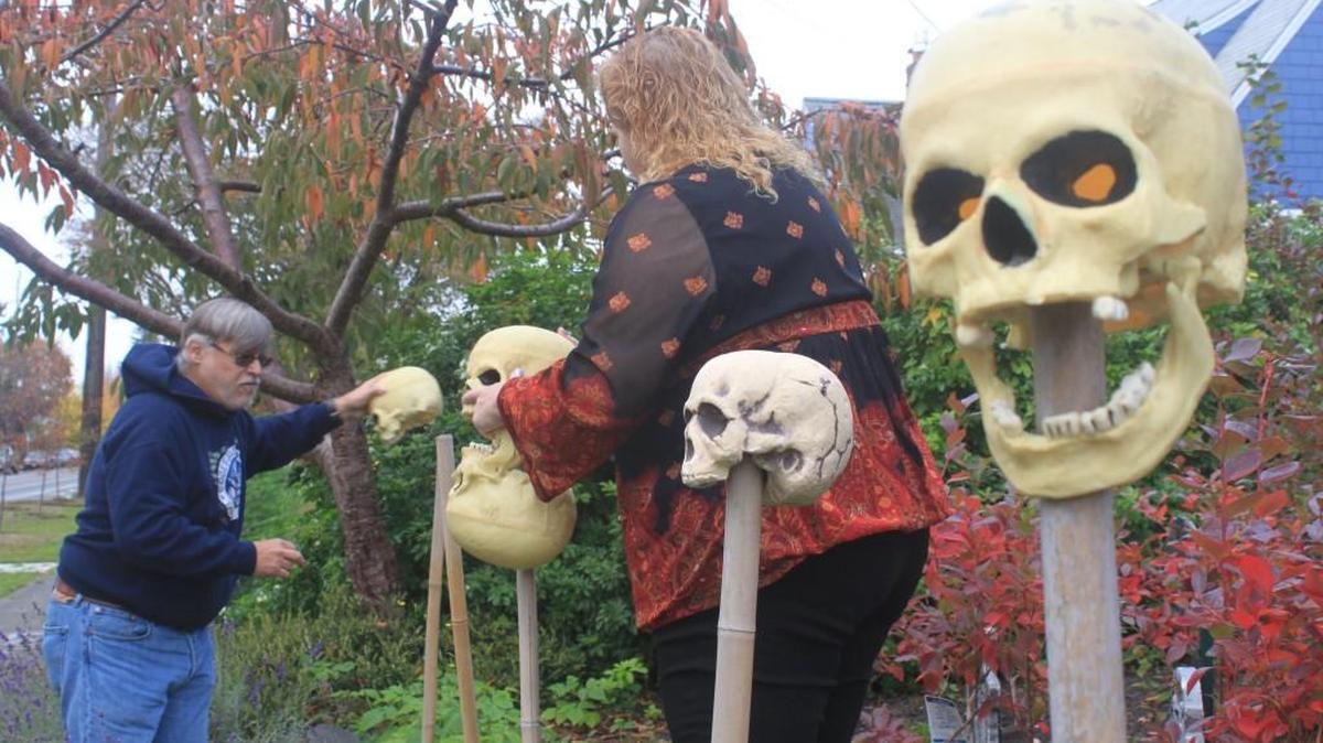 John and Jeanette Smith position skulls in their front “graveyard” this month in Tacoma in preparation for their Halloween haunted house.