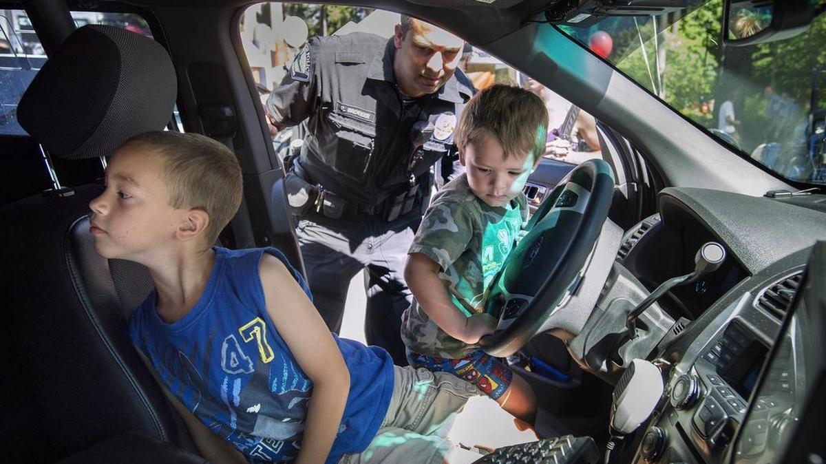 
Josiah Unangst, left, 9, and his brother Charles, 2, explore the inside of Lacey police officer Rich Broeker’s police cruiser during the inaugural Cops, Cars ’n Kids event at the Lacey Police Department on Saturday.
