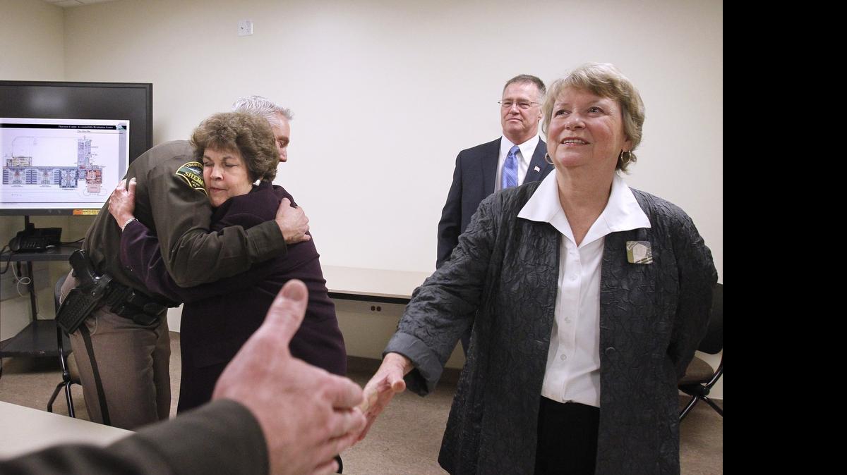 
Sheriff John Snaza hugs Thurston County commissioner Cathy Wolfe as fellow commissioners Bud Blake and Sandra Romero are thanked following their during their announcement of the long-awaited agreement on the opening of the Accountability and Restitution Center in Tumwater on Friday, Jan. 30, 2015. 
