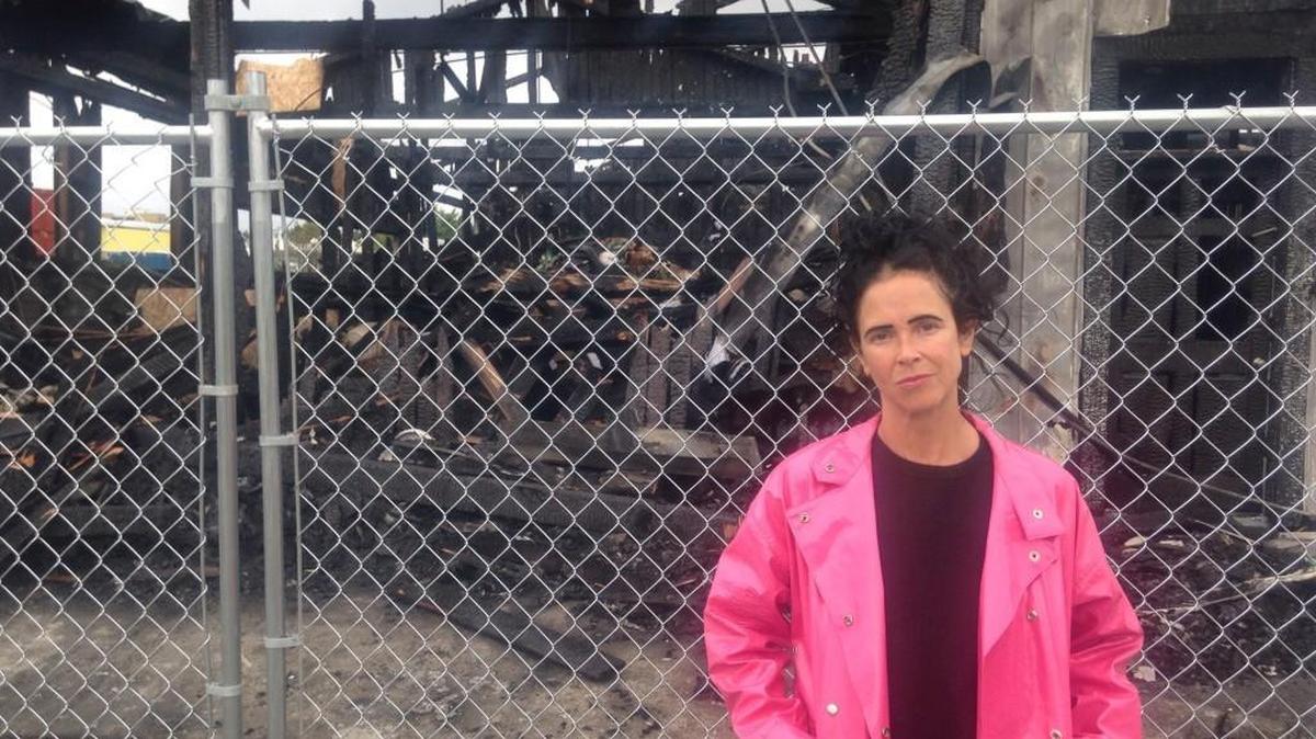 Magic Kombucha founder Rachel Carns stands outside the charred remains of the Adams Street warehouse where all of the kombucha producer’s inventory was stored. Carns is determined to rebuild.