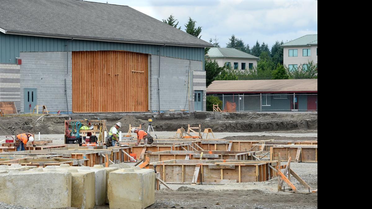
The foundation begins to take shape Tuesday at the site of the new $18.9 million dollar Peter G. Schmidt Elementary School in Tumwater.  The new 60,000 share-foot complex will use the existing gymnasium, seen on the left, and is scheduled for completion in time for the 2016 school year. Forma Construction is doing the work.
