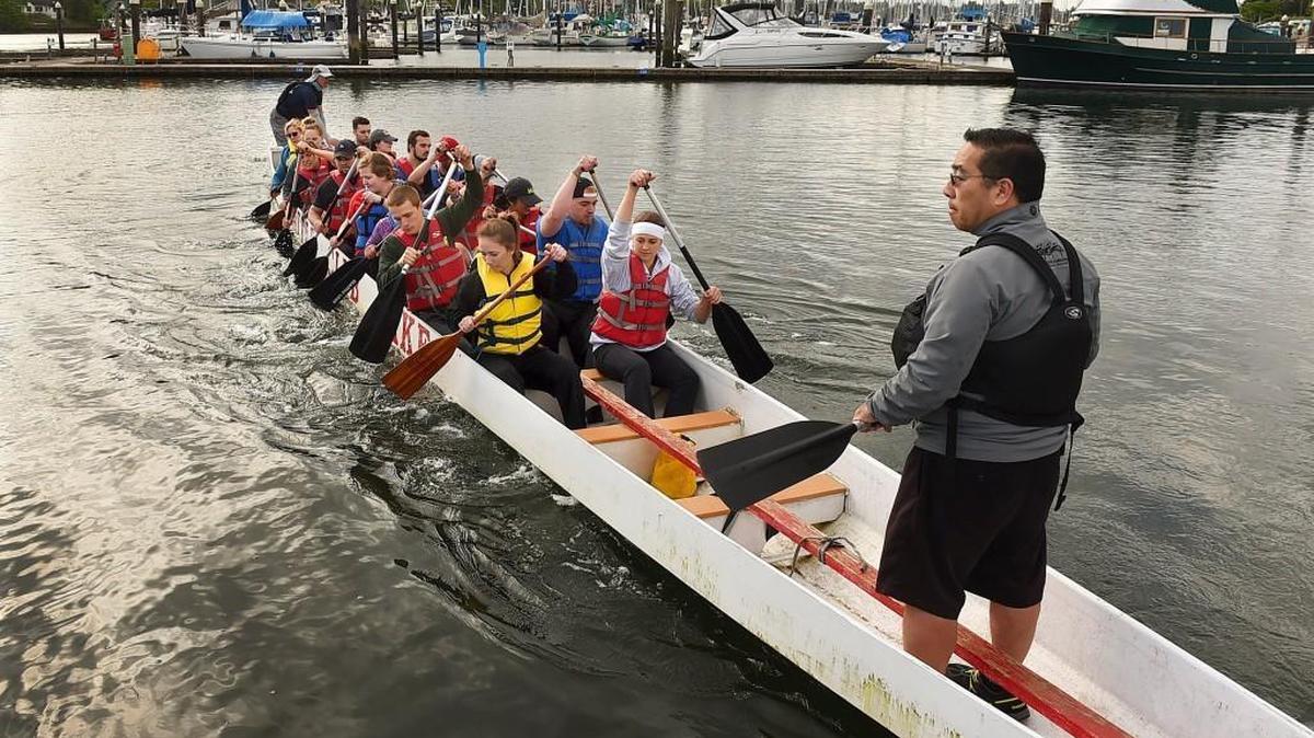 Training under a welcome break from the weekend showers the Associated Students of Saint Martin's University dragon boat racing team sets out from the Swantown Marina area for an early morning practice April 24th in Budd Inlet. Preparing for next Saturday's annual Dragon Boat Festival hosted by the university at the nearby Port Plaza the team was led by training coach Koichi Kitazumi (right) and boat tiller Matthew Goossen from the Kaikane USA and Seattle Sake Dragon Boat Club respectively. Both regional organizations offer both training support and even the use of their boats with the goal to promote and grow the amateur dragon boat sport. This year's Festival will be held on April 30th at Olympia's Port Plaza with more information available on the web at: www.stmartin.edu/news-events/university-events/dragon-boat-festival.