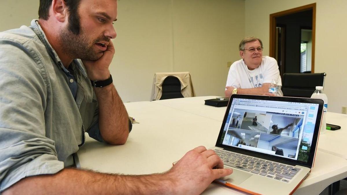 Meeting at the new Lacey location for the Thurston County Veterans Services last week, Derek Revisky, the team lead for the Thurston SideWalk Veteran Assistance organization, calls up photos taken at the volunteer painting party from late April at the offices as Bob Jones, city of Olympia volunteer liaison on veterans issues, outlines the program’s goals.